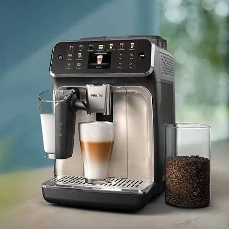 Philips espresso machine brewing latte with milk frother and coffee beans nearby