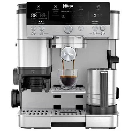 Ninja coffee maker brewing espresso into glass cup with digital display and milk frother