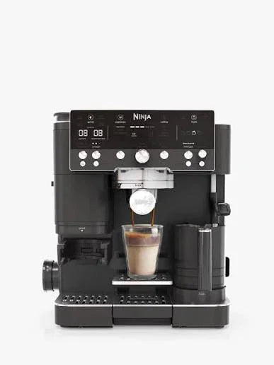 Ninja espresso machine brewing coffee into glass cup, sleek black design with digital display
